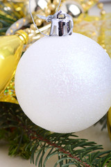 festive golden christmas decoration, candles, white balls, green fir tree branch, close up