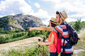 Hiking - Couple of hikers are smiling in front of a mountain during their trip - caucasian people - people, nature and lifestyle concept