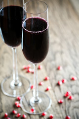 Two glasses of champagne with pomegranate seeds