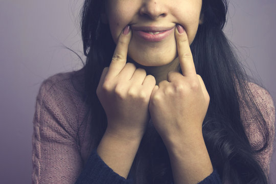Fake smile women her fingers