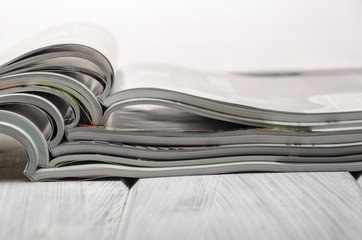 stack of magazines on a white wooden background