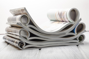 stack of magazines on a white wooden background