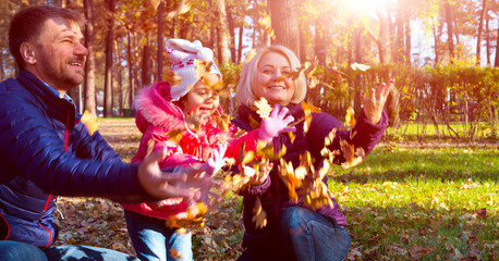 Fototapeta na wymiar Carefree European Family Playing in Autumnal Park