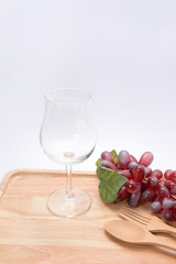 glass and grapes on a wooden floor.