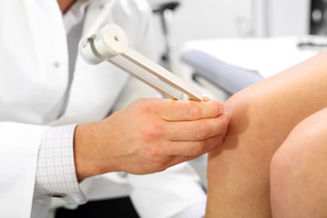 Kamerton, badanie ortopedyczne.Lekarz ortopeda bada kolano pacjenta przy użyciu kamertonu. - obrazy, fototapety, plakaty