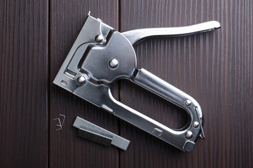 manual staple gun on venge wood, top view