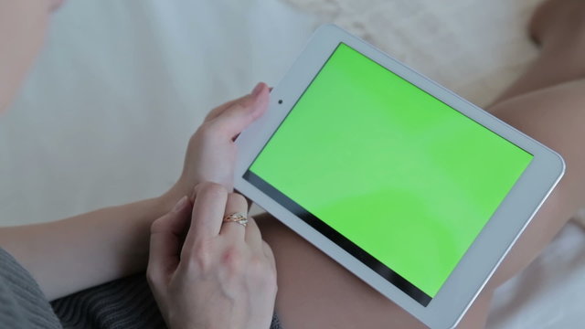 Woman watch on green screen tablet computer closeup. The concept of buying Christmas gifts via the Internet