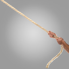 Hands of people pulling the rope on a gray background.  Competition concept
