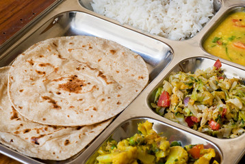 Simple food from India in selective focus - thali, subji, rice, dal and some chapati