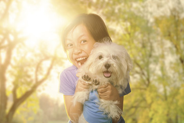 Cheerful little girl and puppy at the park
