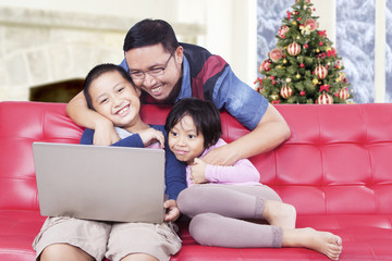 Father and kids watching movie on laptop