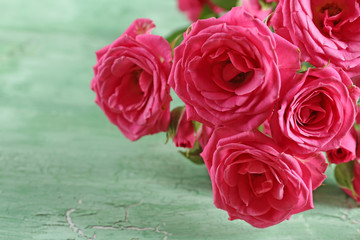 Naklejka premium Beautiful roses on wooden background