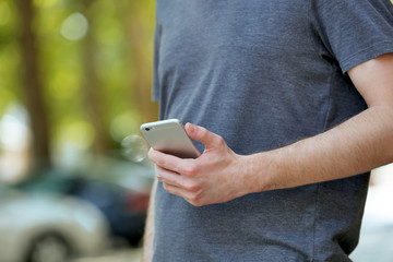 Man holding smart mobile phone outdoors