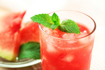 Cold watermelon desserts and drinks in glasses, on wooden table background