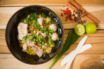 bowl of noodles with vegetables and soft boiled egg on wooden ta