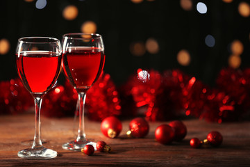 Wine glasses with Christmas decorations on wooden table