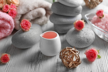 Composition of flowers, salt and stones on white wooden background, in spa salon