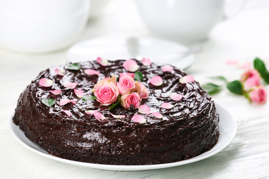 Chocolate cake decorated with flowers on the table