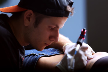 Tattooist makes tattoo, close up
