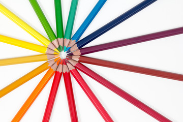 color pencils arranged in a circle top left on white background, top view