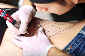 Tattooist makes tattoo, close up