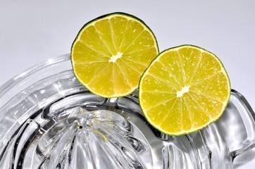 Cut lime citrus halves on glass juicer