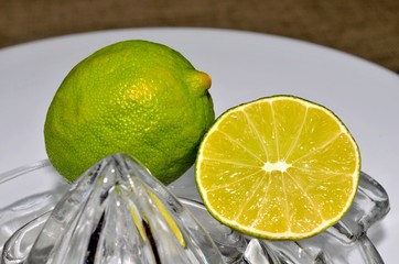 Cut and whole lime with glass juicer