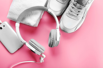 Headphones and sport equipment on pink background