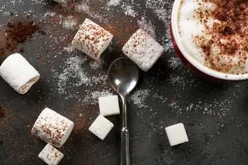 Cup of coffee and sweets on black wooden background