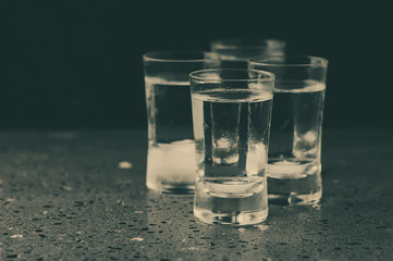 A glass of vodka on the black table