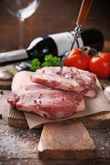 Marbled beef steak and spices on wooden background