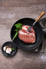 Marbled beef steak on pan and spices on wooden background