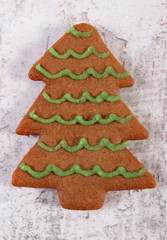 Fresh baked decorated gingerbread on old wooden background, christmas time