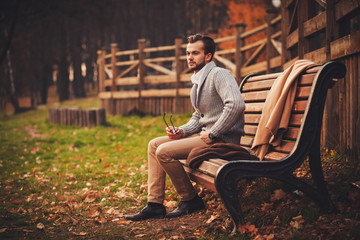 handsome man sitting in bench