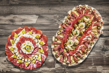 Two Platters of Savory Antipasto Meze Appetizers, Placed on Old Lacquered, Peeled-off Varnished Wooden Garden Table Surface.