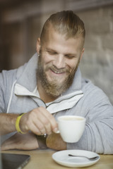 handsome bearded mandrinking coffee in coffee shop