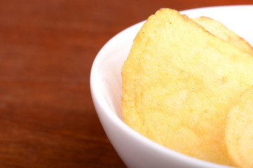 Crispy potato chips close up on white plate