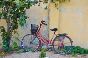 Fototapeta na wymiar old bicycle on yellow wall in vietnam