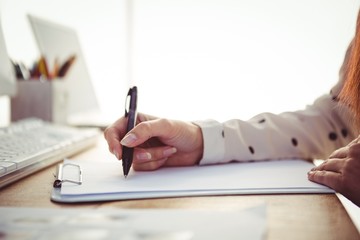 Cropped image of woman writing on notepad