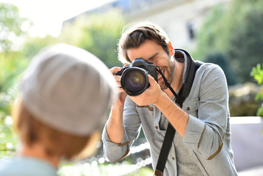 Photographer taking picture of trendy model in park