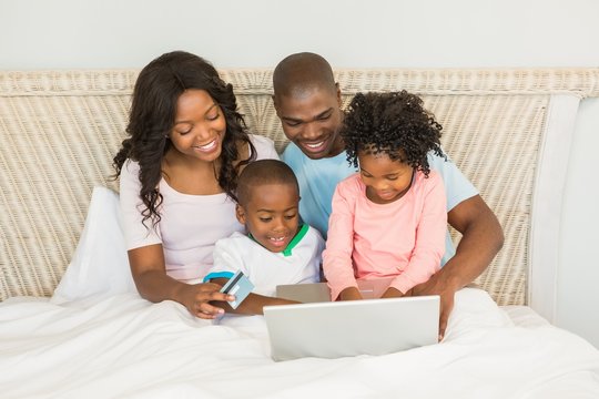 Happy family shopping online with laptop