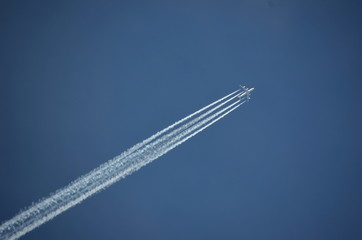 An airplane trail across the blue sky isolated 