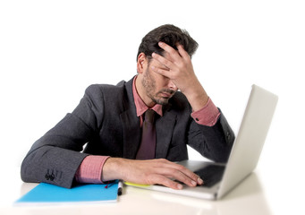 young businessman sitting at office desk working on computer laptop desperate worried in work stress