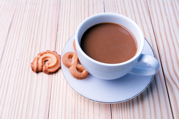 cup of coffee and cookies on wooden