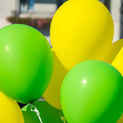 Bright yellow and green balloons on a city street