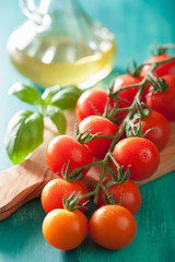 cherry tomatoes and olive oil over turquoise background