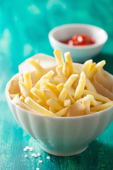 french fries with ketchup over green background