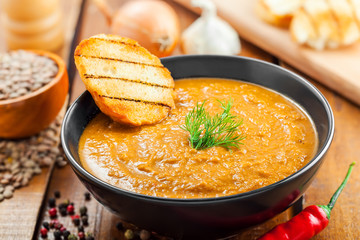 Bowl of lentil cream soup on table, healthy lunch cooking