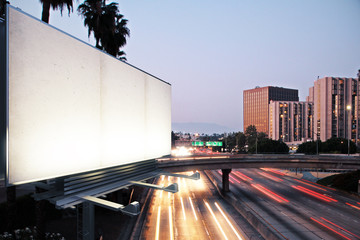 Blank white billboard on the background of the highway at evenin - obrazy, fototapety, plakaty