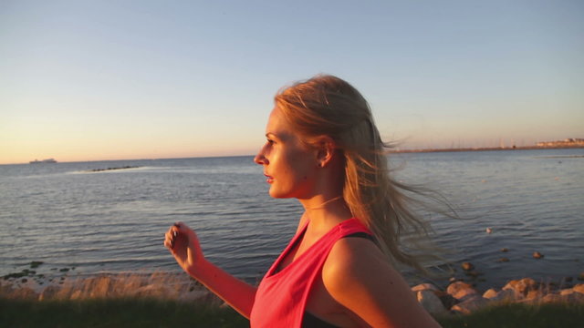 caucasian woman power walking along the ocean at sunset. Good for concepts such as power walking, healthy living and workout